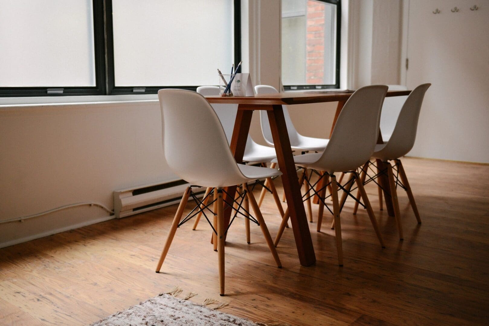 A table and chairs in front of windows.